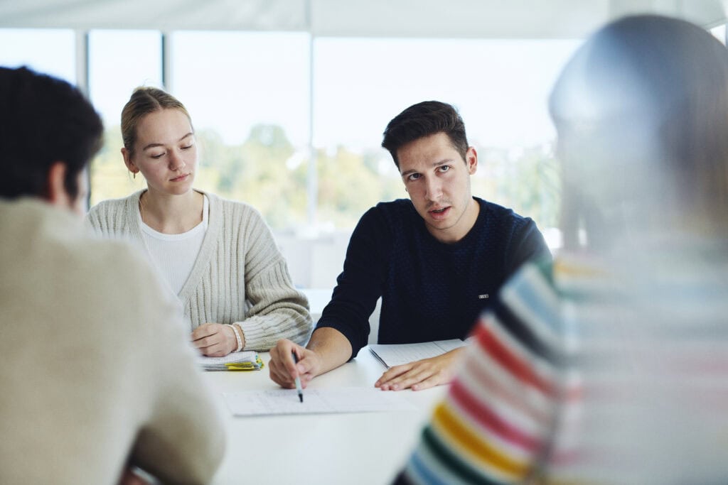 Junge Wissenschaftlerinnen und Wissenschaftler im Gespräch bei einer Besprechung